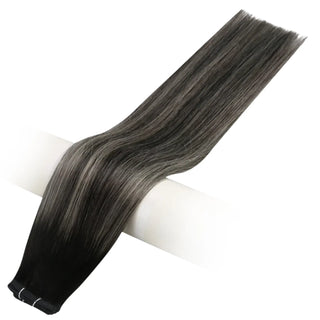 Virgin hair weft featuring black strands infused with soft blonde highlights.
