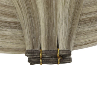 Lightweight flat silk weft extensions in ash brown balayage with bright blonde streaks.
