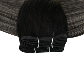 Fullshine invisible weft with deep black roots lifted by blonde highlight panels.